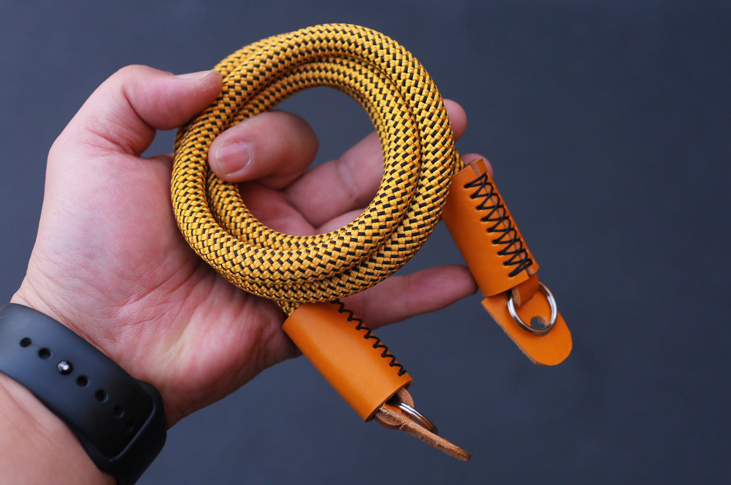 Bright orange grained leather detail on handmade camera strap