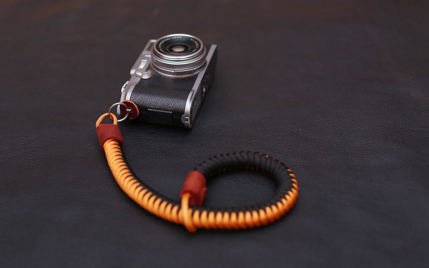 16mm paracord wrist strap placed beside compact film camera