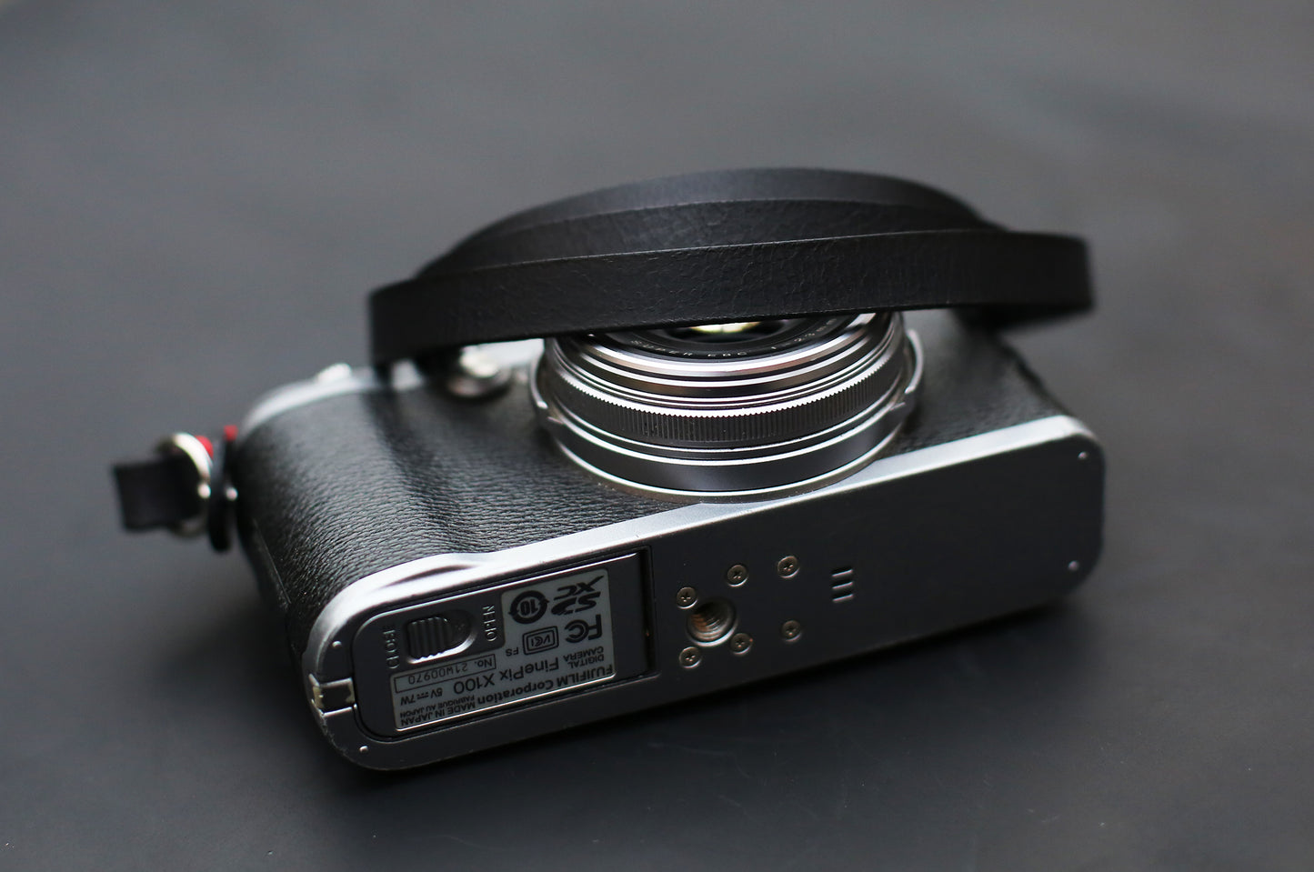 Black camera strap on silver and black mirrorless camera body