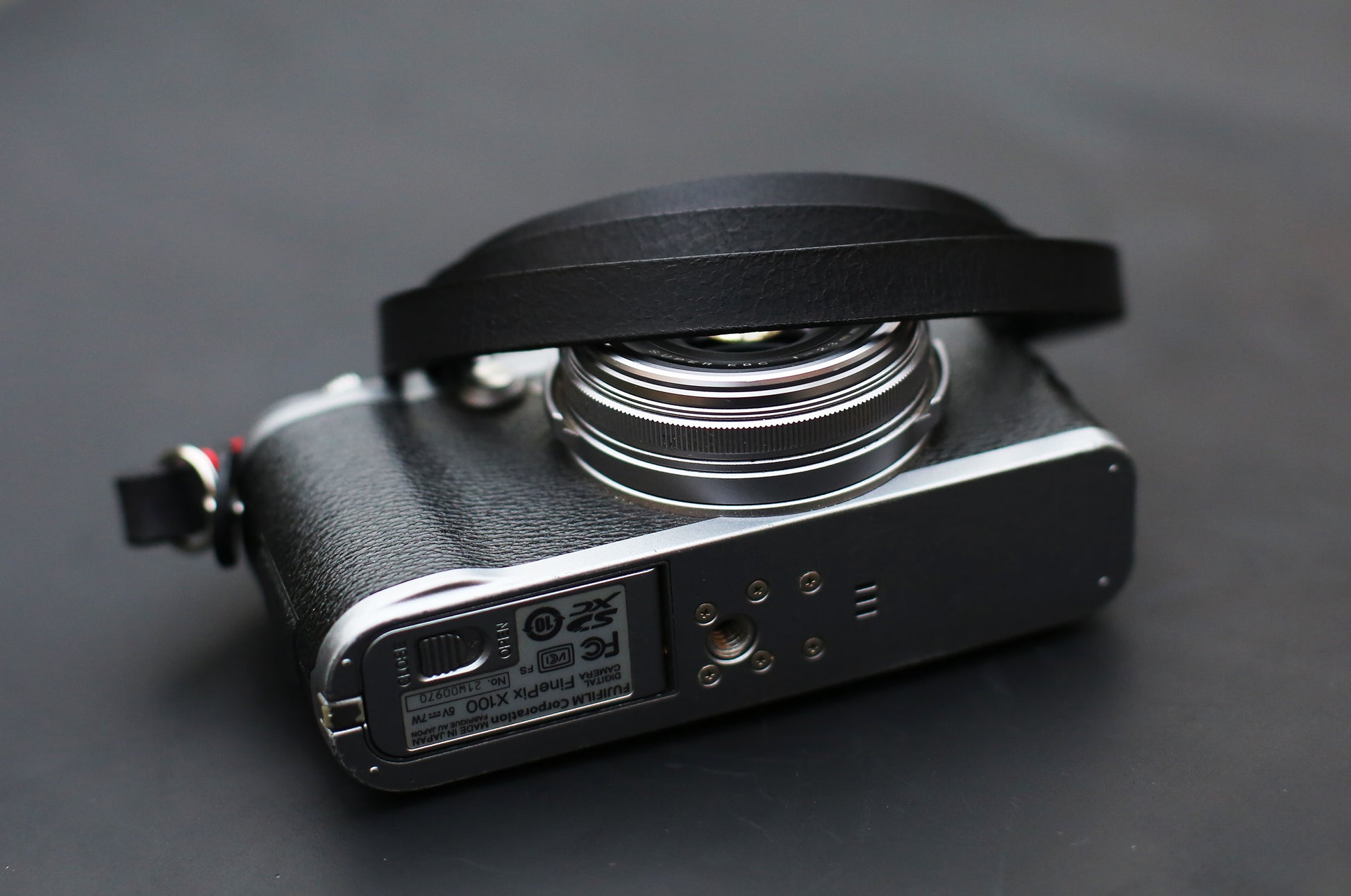 Black camera strap on silver and black mirrorless camera body