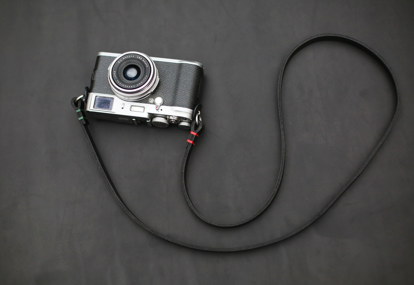 Black leather camera strap with red waxed thread accents, 10mm width, handcrafted for photographers