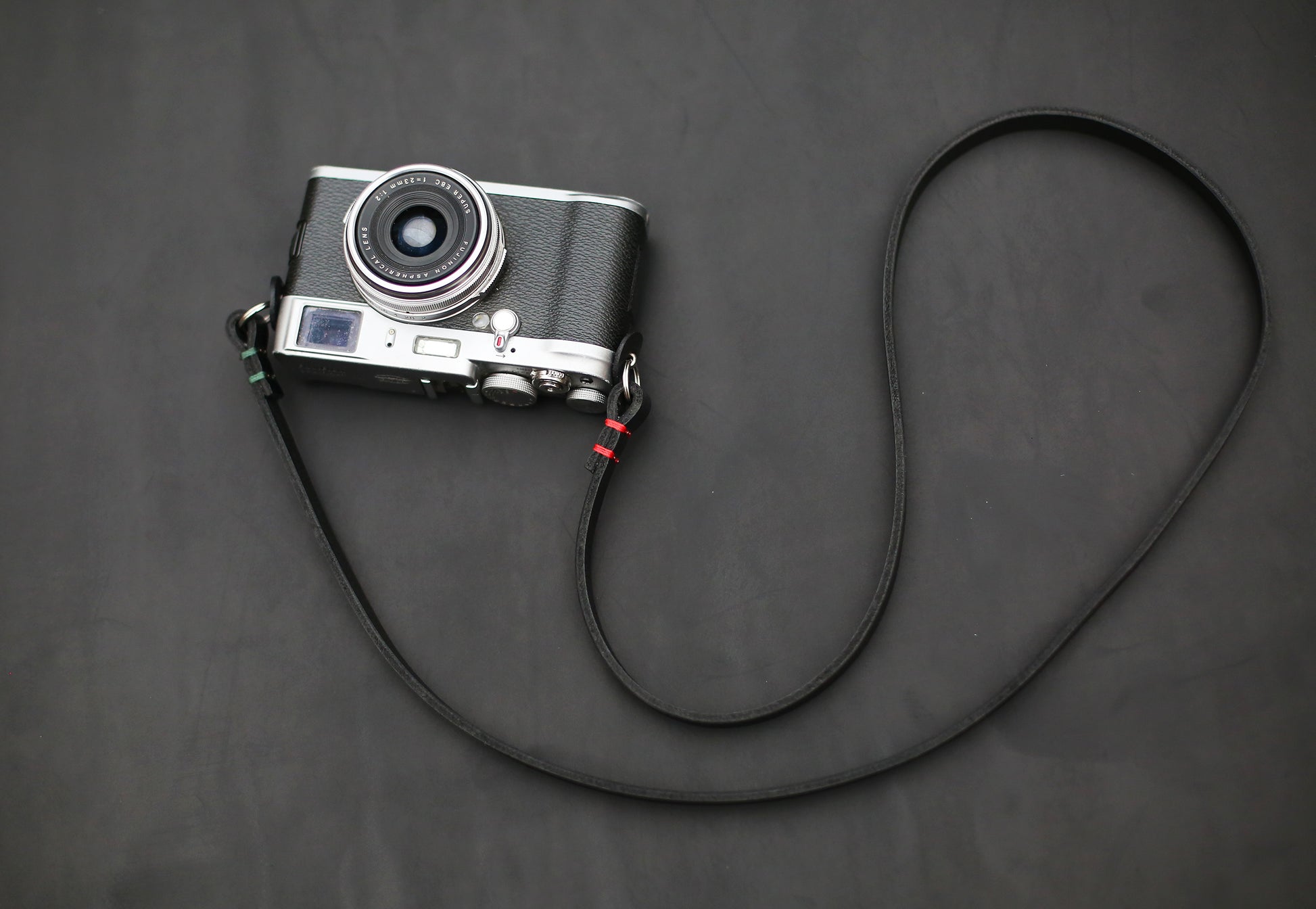 Black leather camera strap with red waxed thread accents, 10mm width, handcrafted for photographers