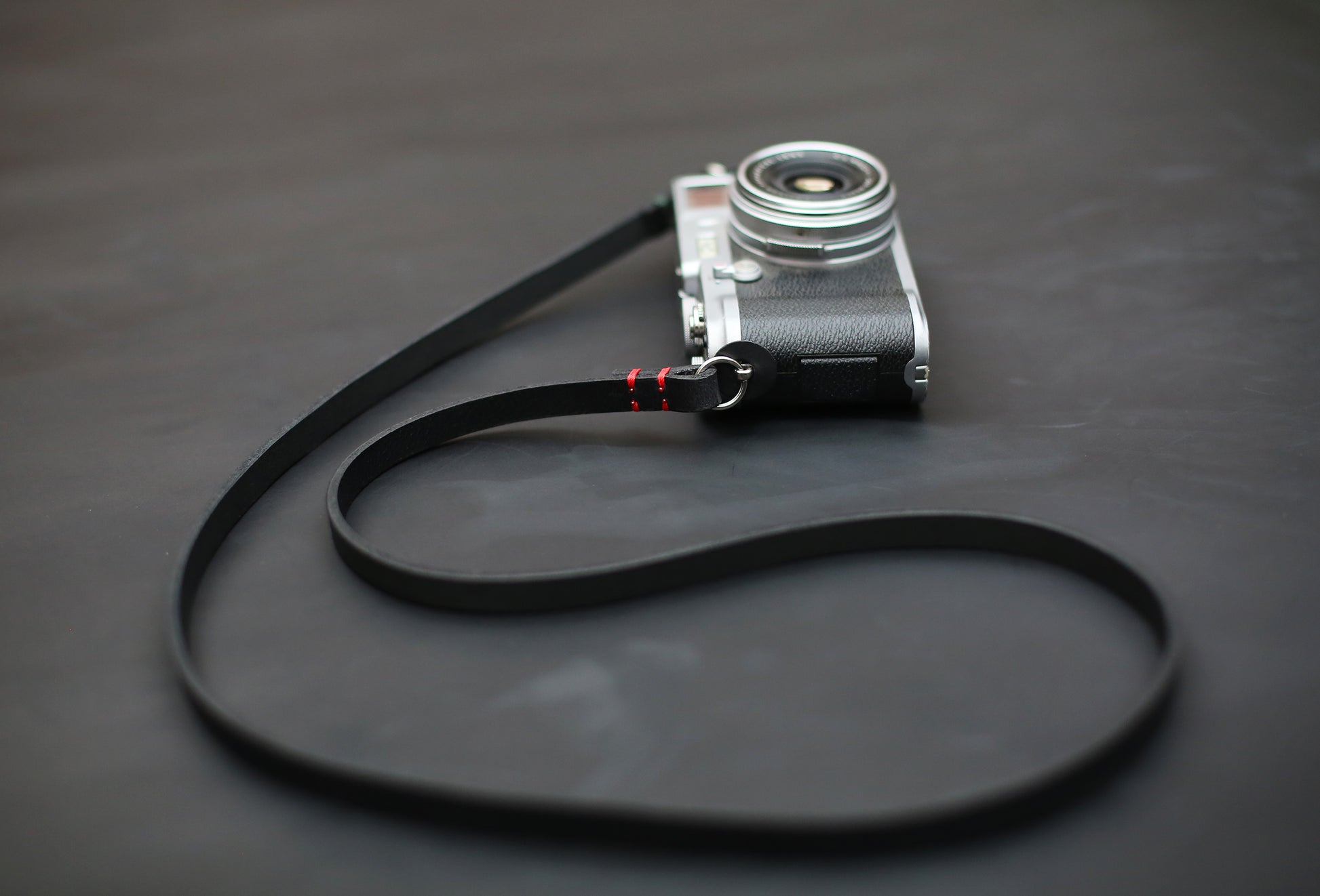 Handmade black buffalo leather camera strap, 10mm wide, minimalist design for mirrorless and film cameras