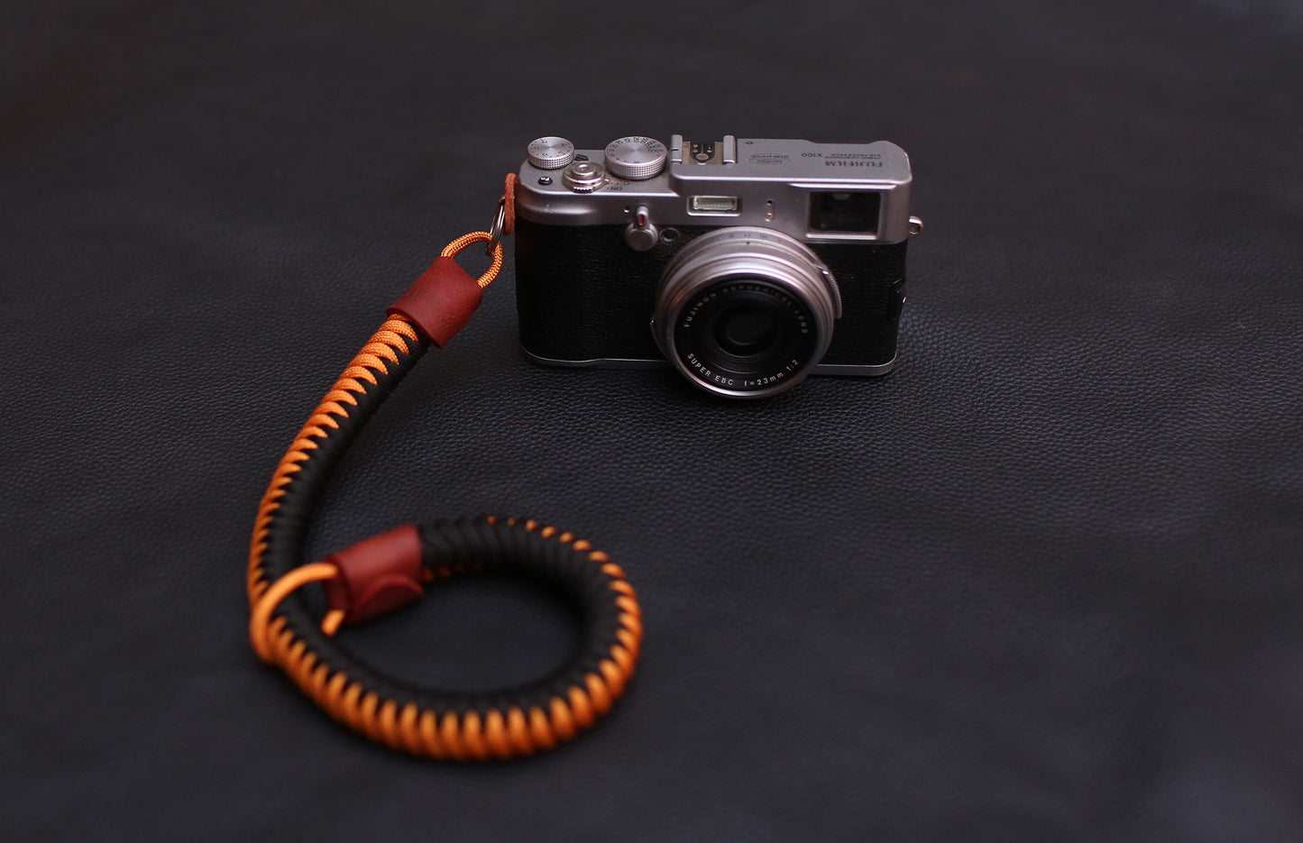 Brown pebbled leather accent on black-gold wrist strap