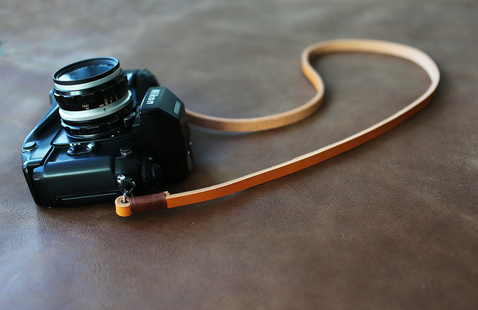 Light brown handmade leather camera strap on vintage camera