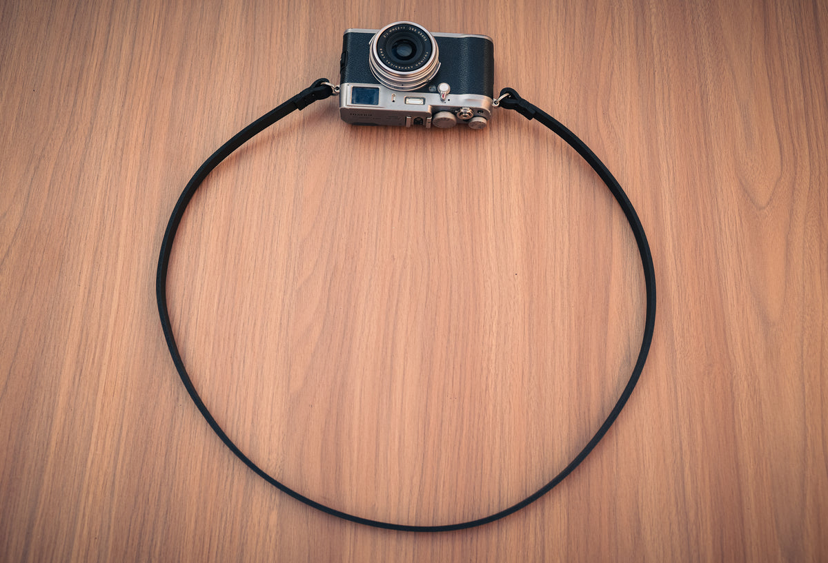 Full view of a handmade black buffalo leather camera neck strap