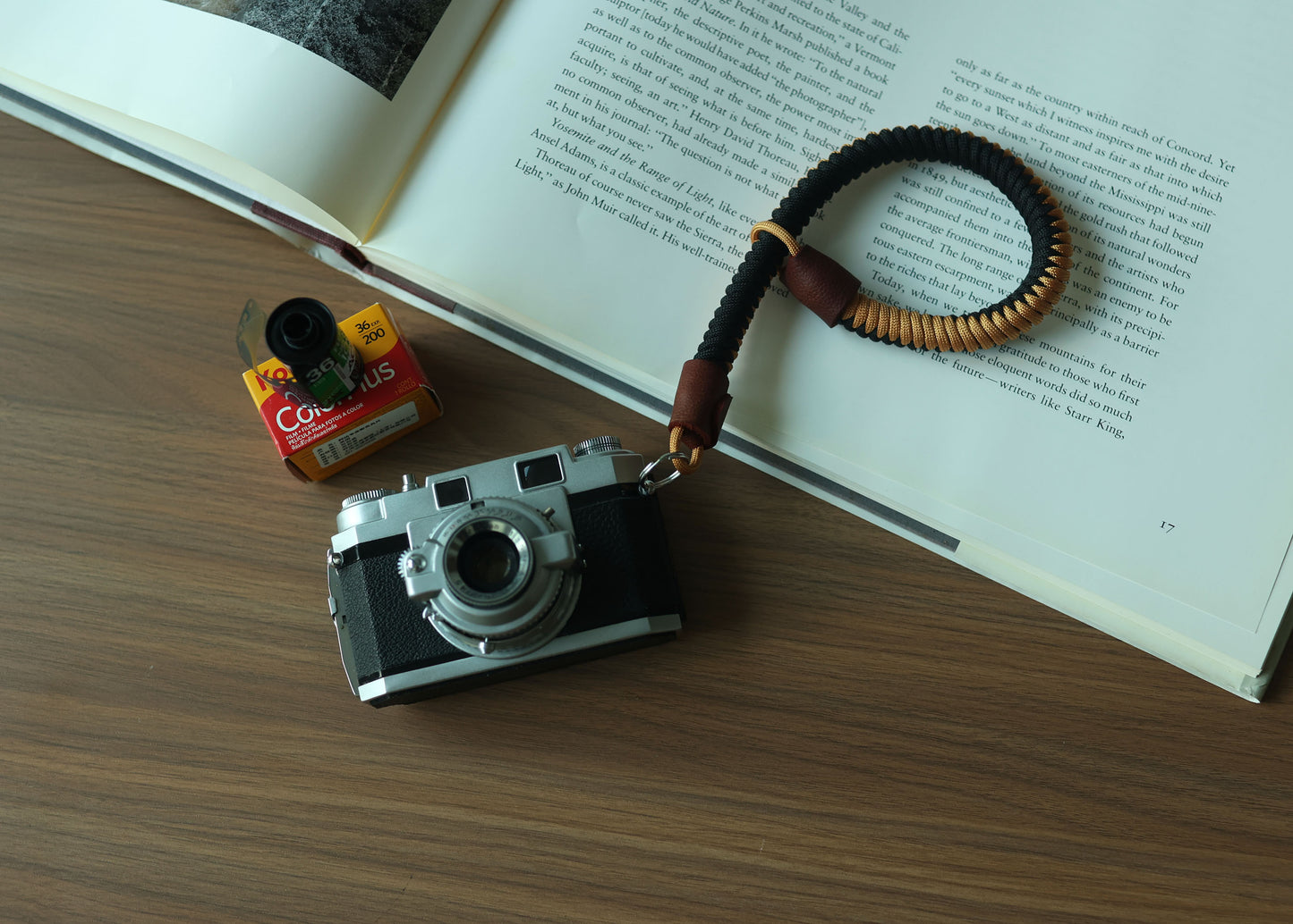 photography-book.jpgBlack and gold braided camera wrist strap displayed with a vintage camera and photography book