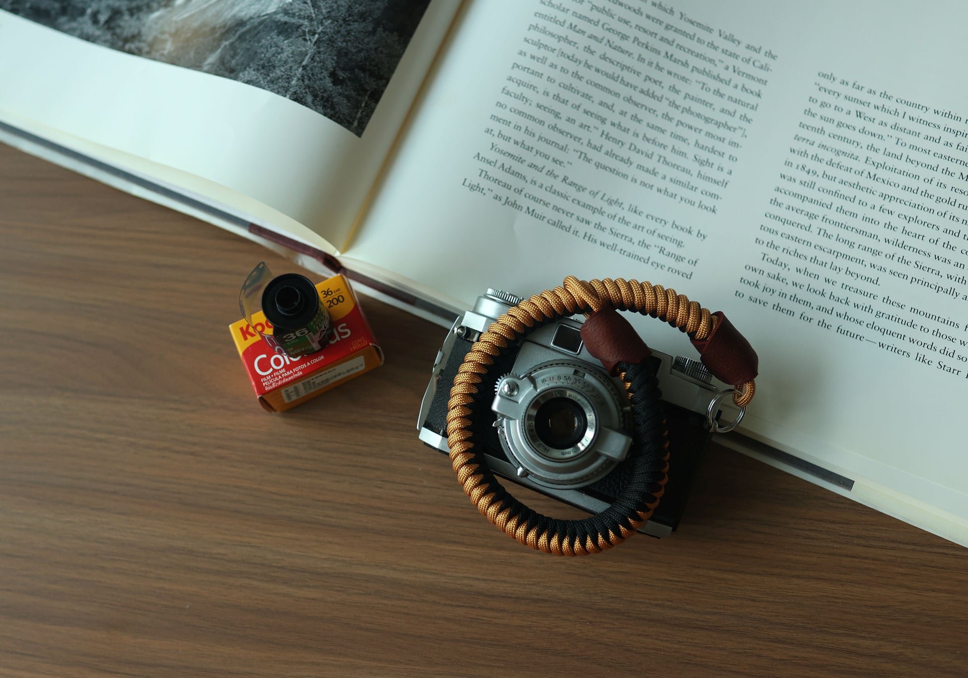 Black and gold paracord camera wrist strap with brown leather ends and metal split ring attachment