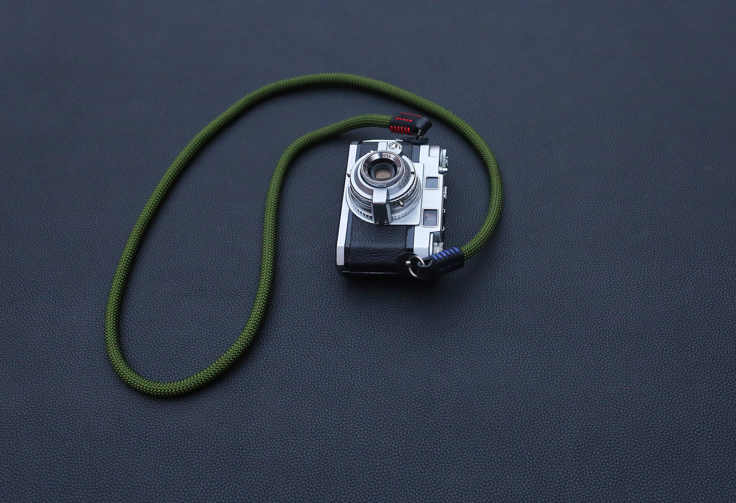green rope camera strap with black leather details