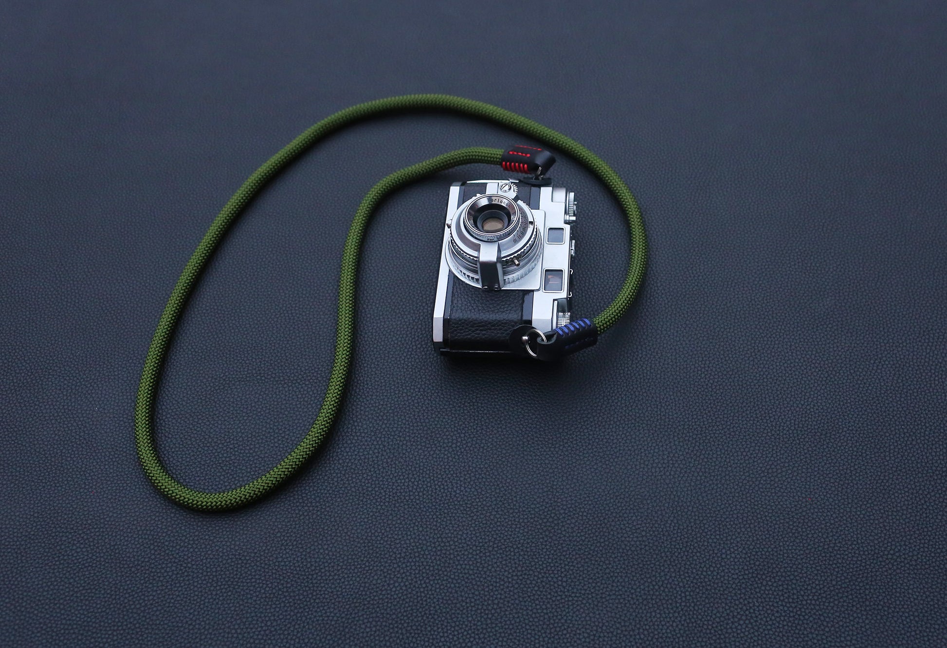 green rope camera strap with black leather details