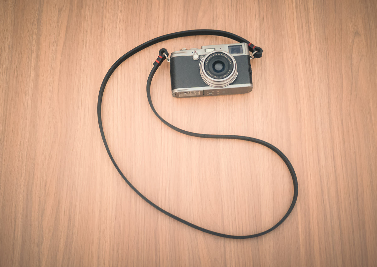 Minimalist black leather camera strap with matching black stitching