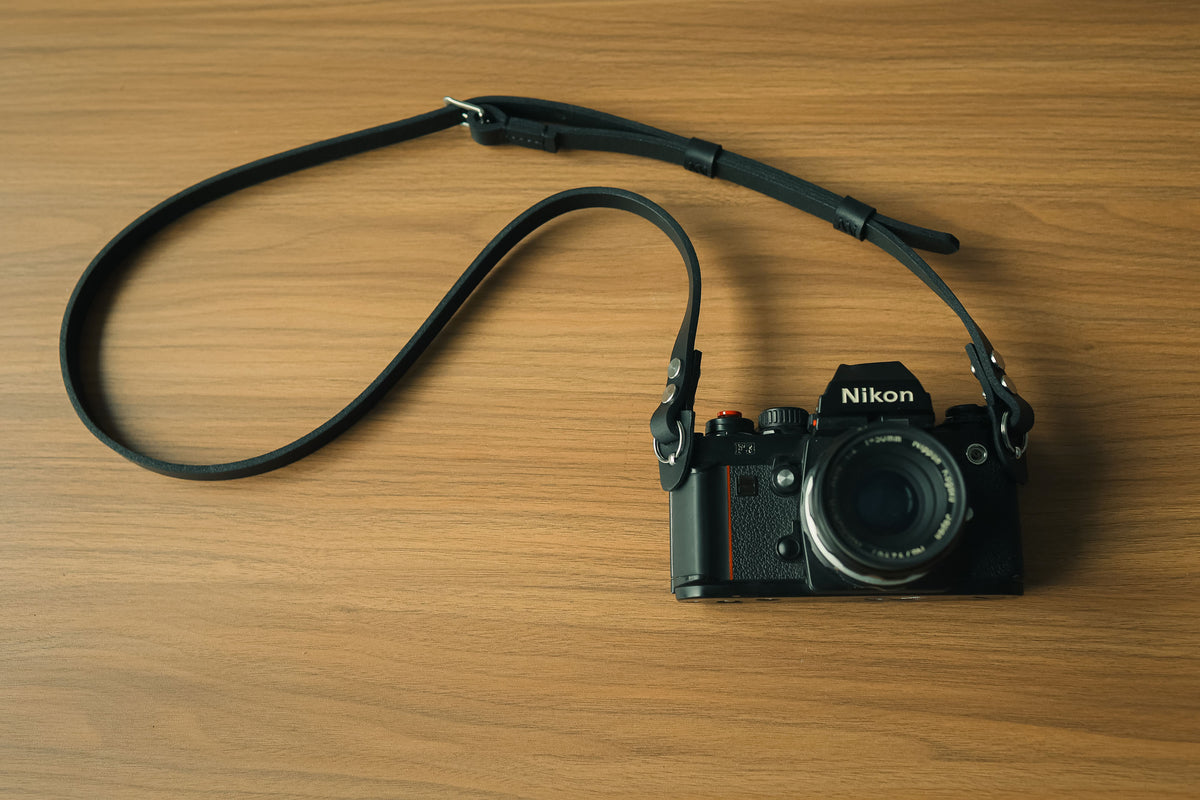 Full view of handmade black leather camera neck strap