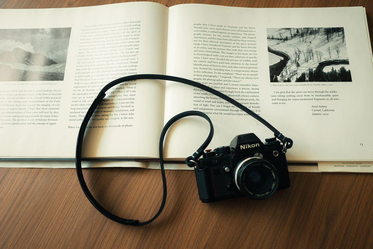 Black full-grain leather camera strap with grey waxed thread detail