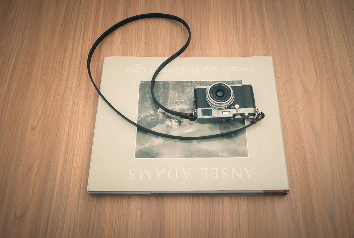 Metal split-ring attachment on the black leather camera strap