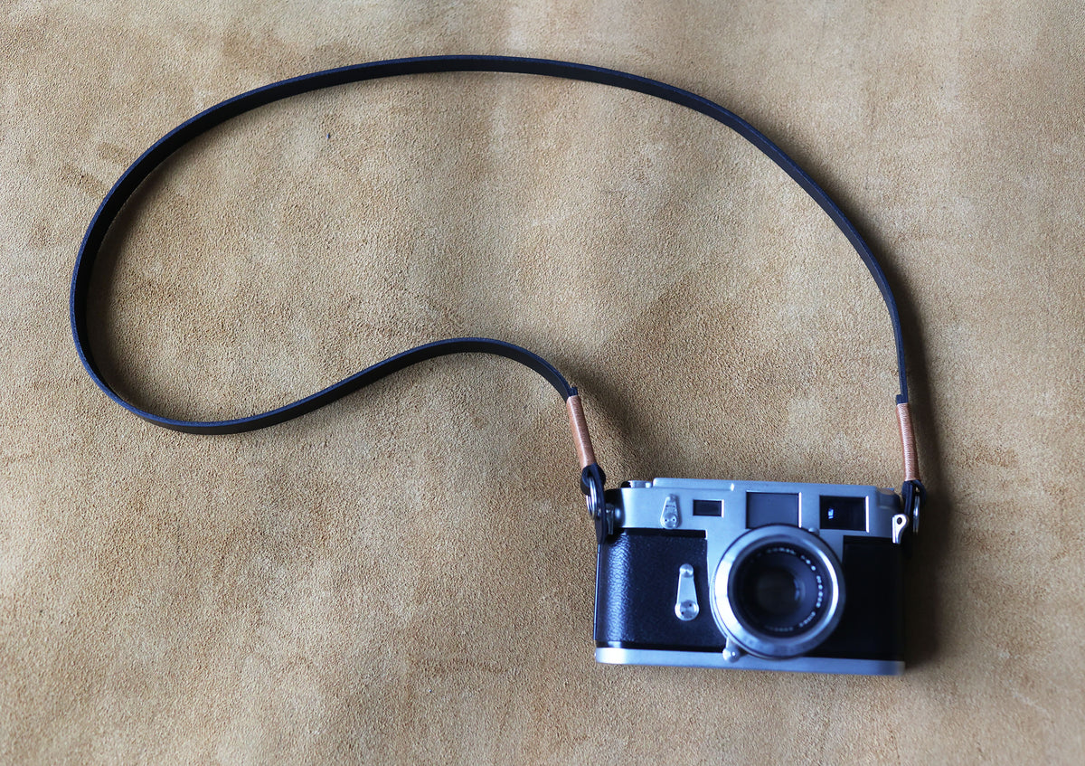 Black leather camera strap paired with a vintage camera for everyday photography
