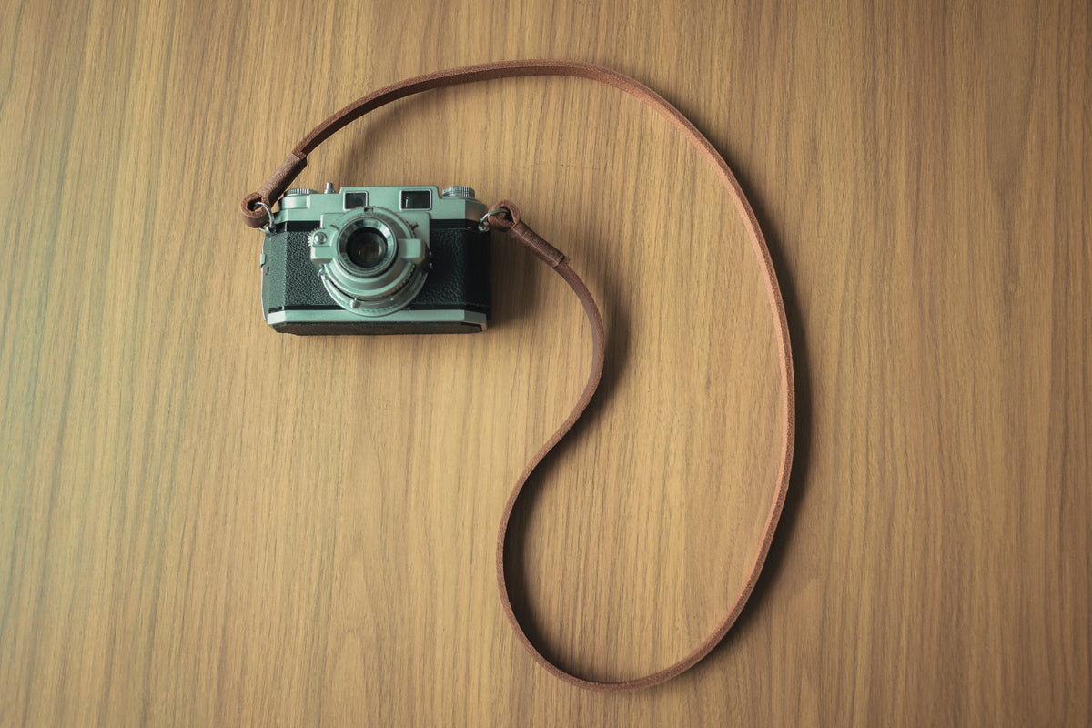 Tan leather strap styled with a vintage film camera