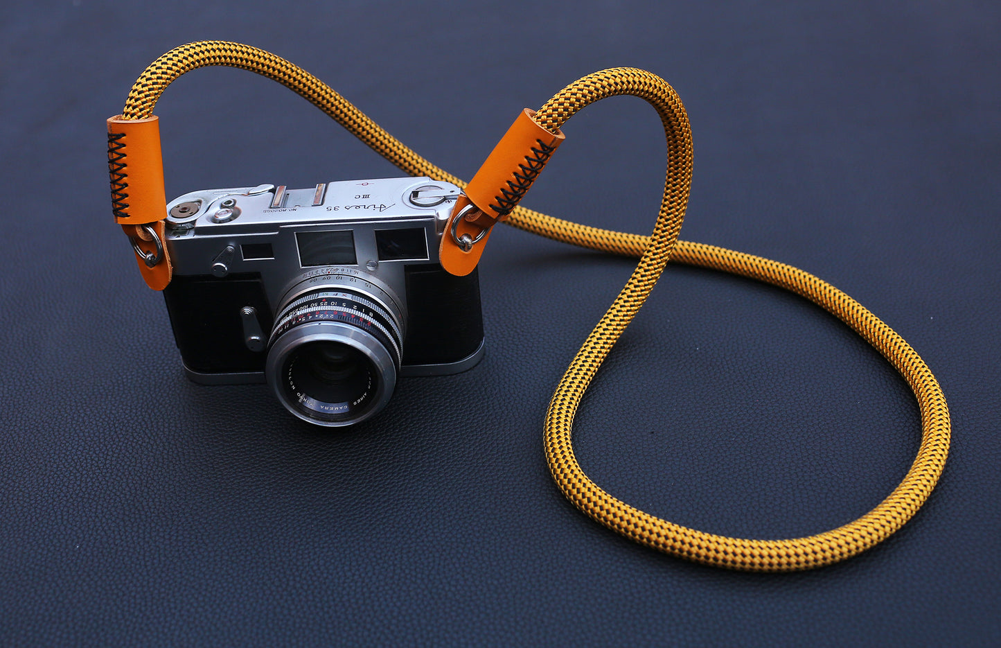 Modern style gold camera strap with bright orange leather finish