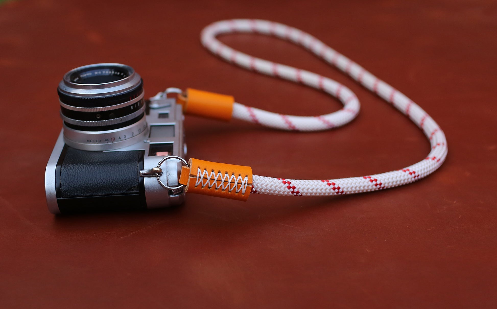 Hand-stitched orange leather ends on a professional rope camera strap
