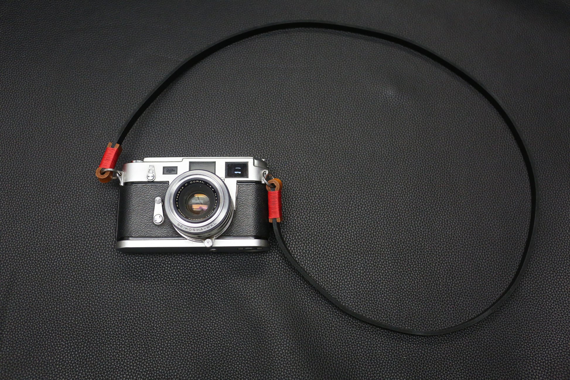 Vintage rangefinder camera with Windmup black leather strap attached.