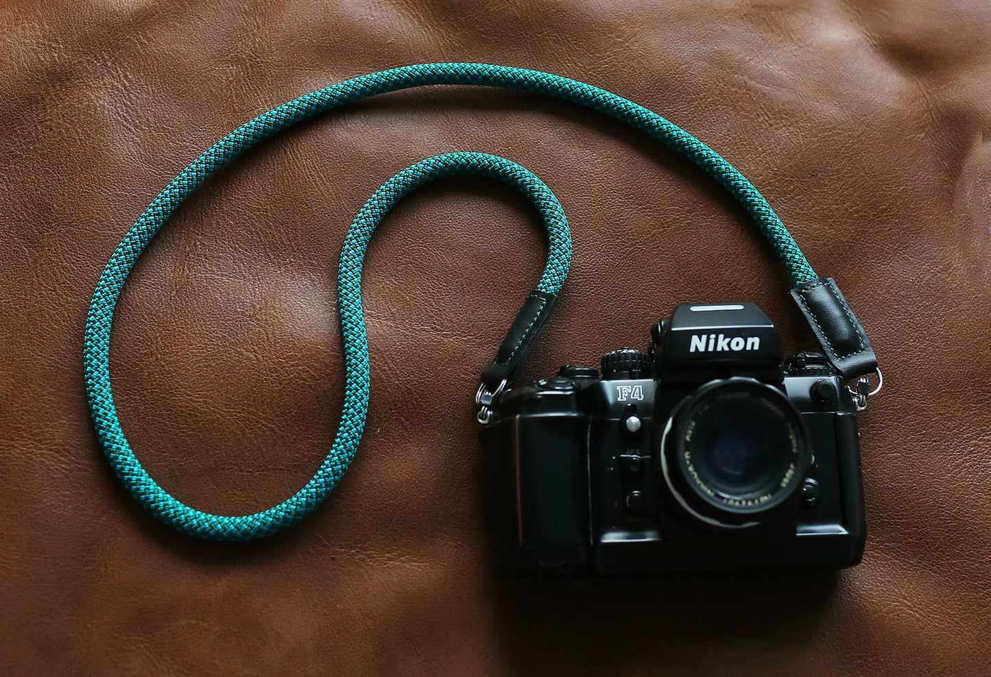 Strap attached to vintage Nikon film camera with split ring connectors