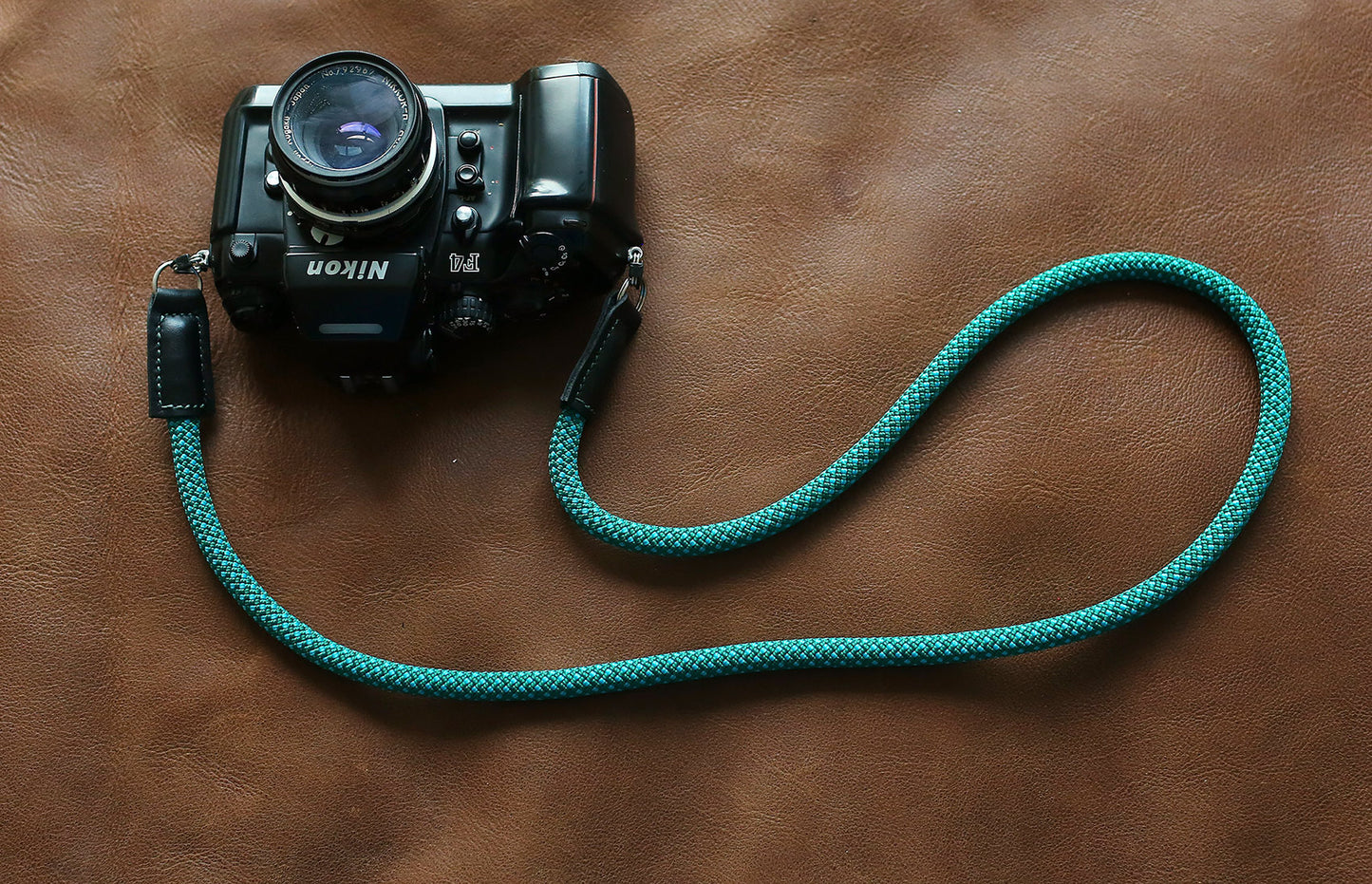 Strap attached to vintage Nikon film camera with split ring connectors