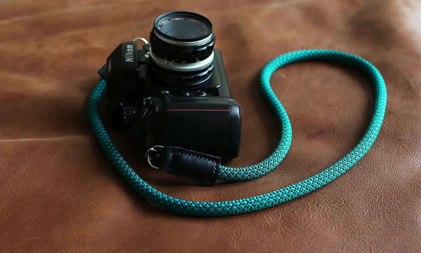 Top-down photo of green-pattern strap with Nikon F4 camera