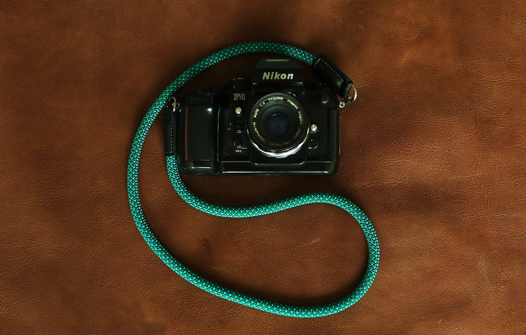 Green and blue woven rope strap displayed with camera gear setup