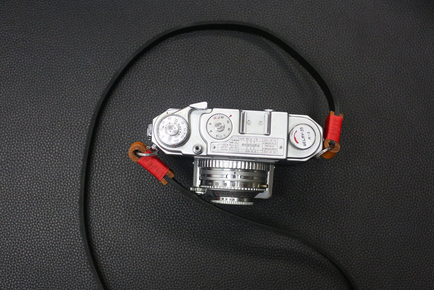 Detail view of leather loop and brass ring on Windmup camera strap.