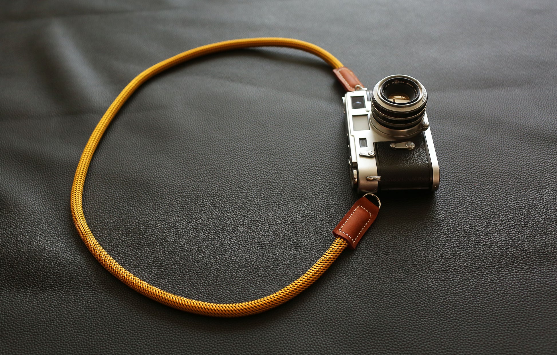 Photographer using a Gold professional climbing rope strap for street photography
