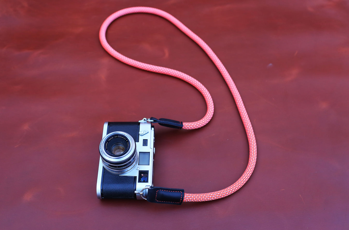 Hand-stitched matte black full-grain leather ends on a red climbing rope