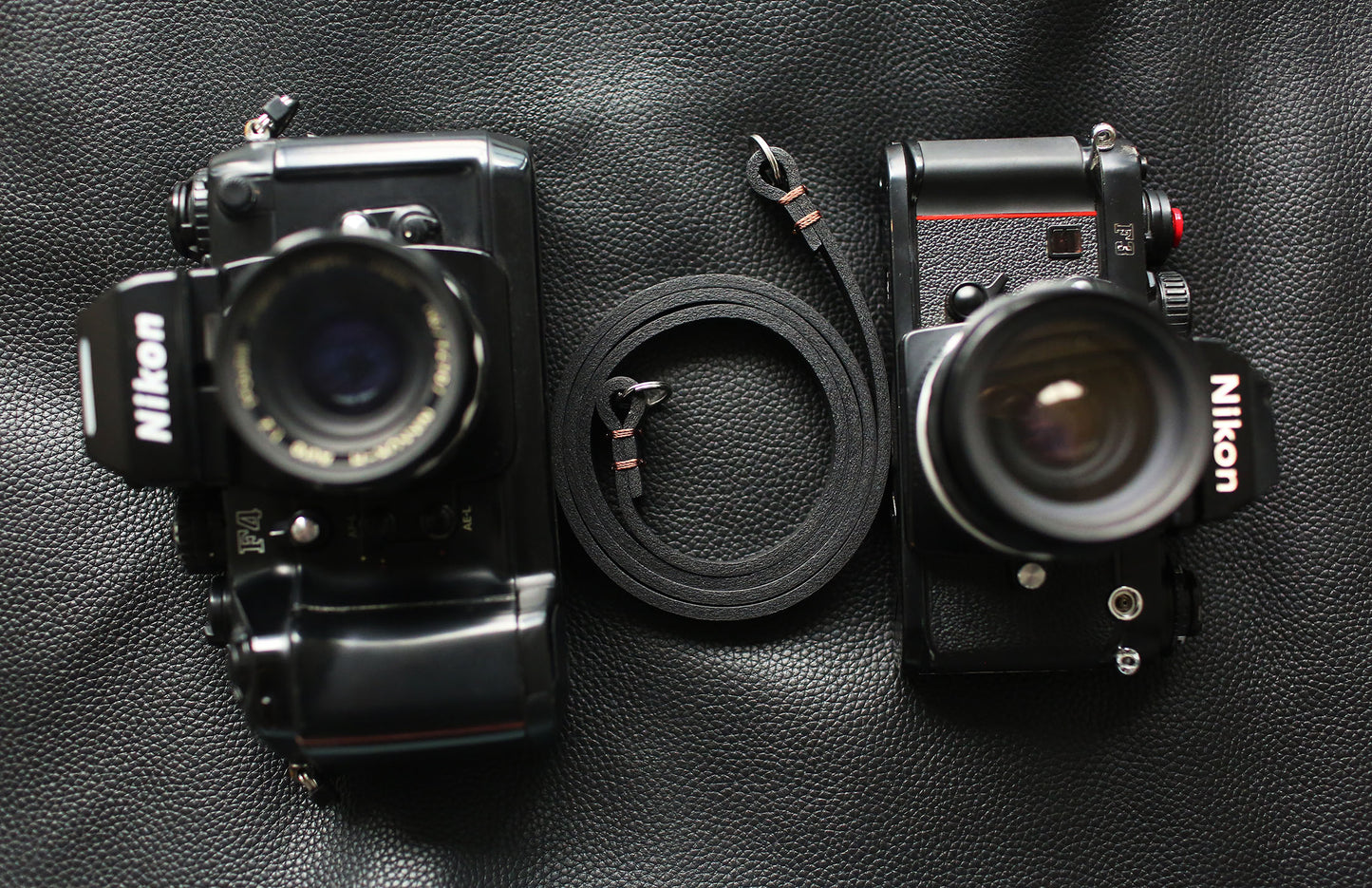 Black minimalist camera strap attached to Leica camera