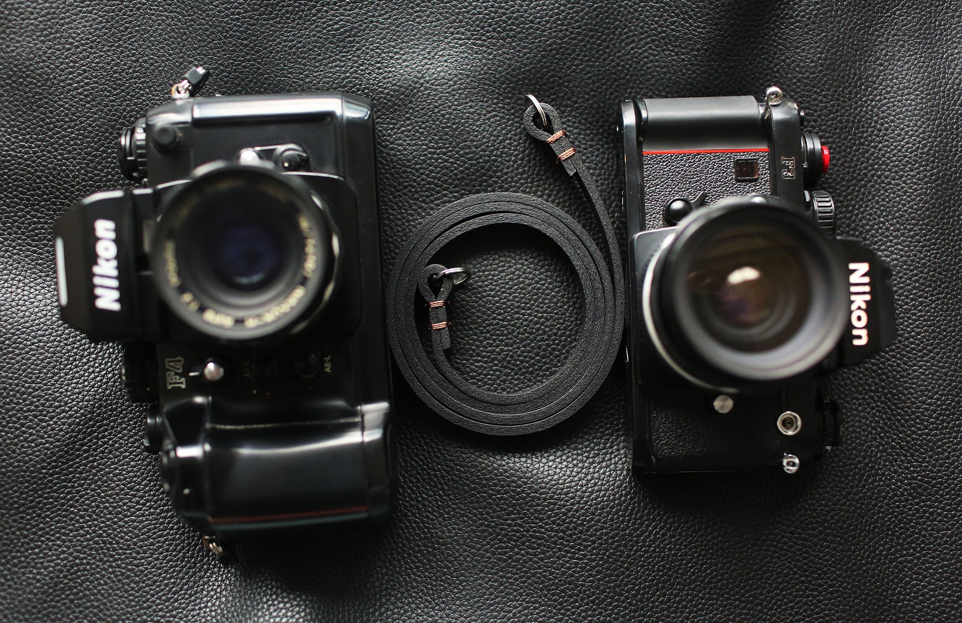 Black minimalist camera strap attached to Leica camera