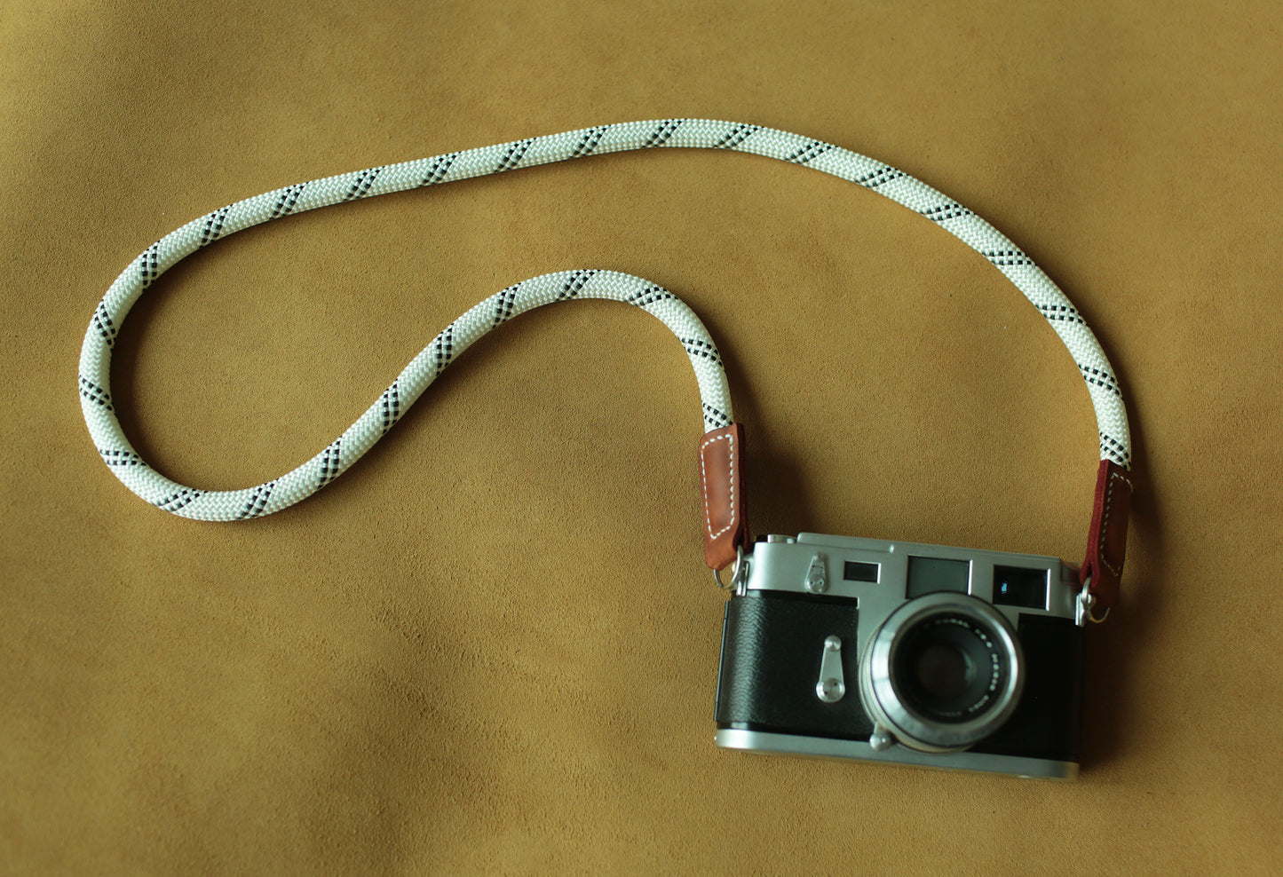 Minimalist white rope camera strap designed for mirrorless cameras