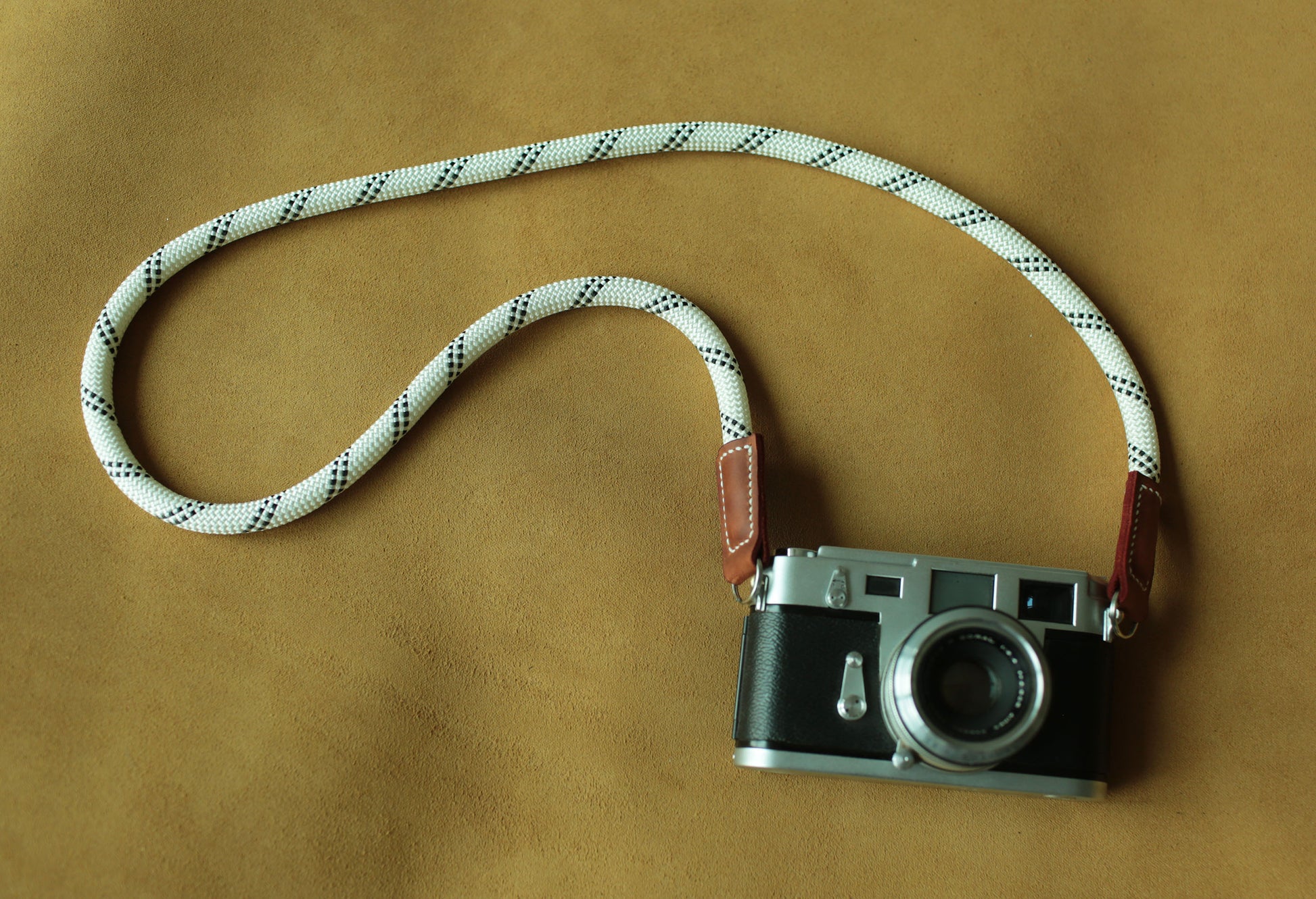 Minimalist white rope camera strap designed for mirrorless cameras