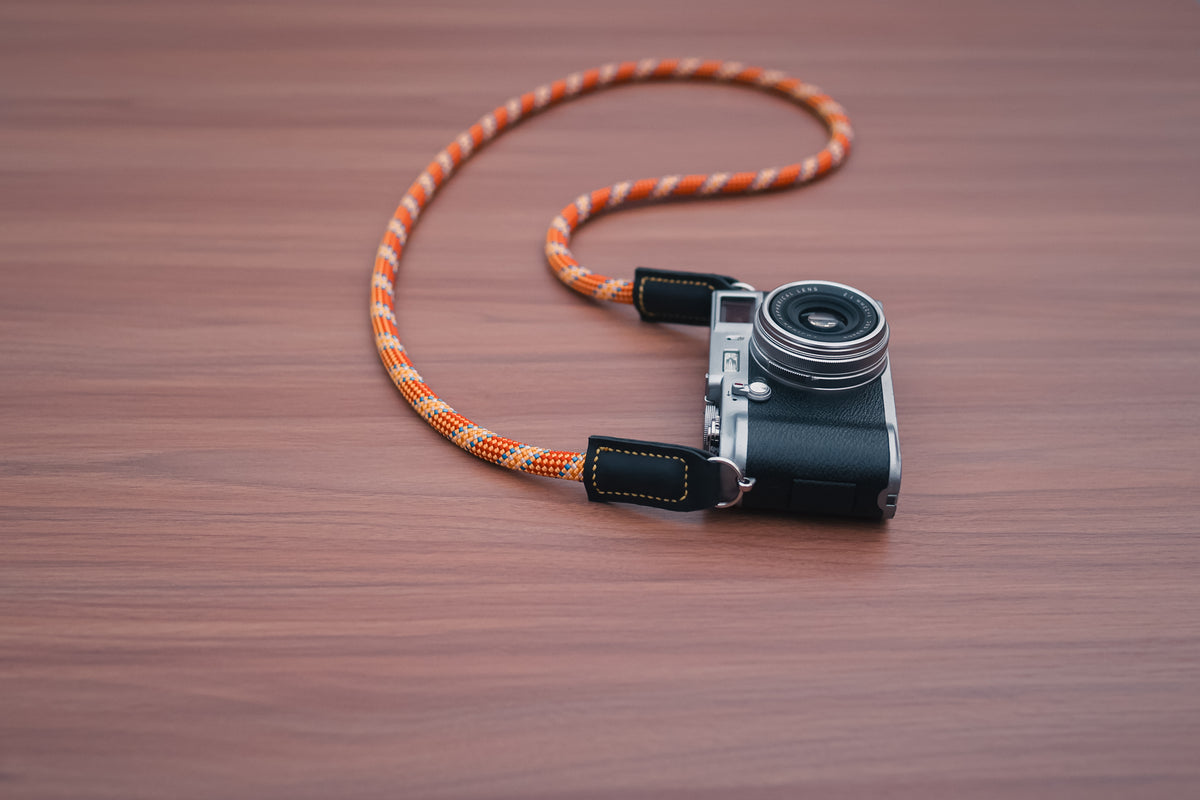 Orange climbing rope camera strap with leather attachment protectors