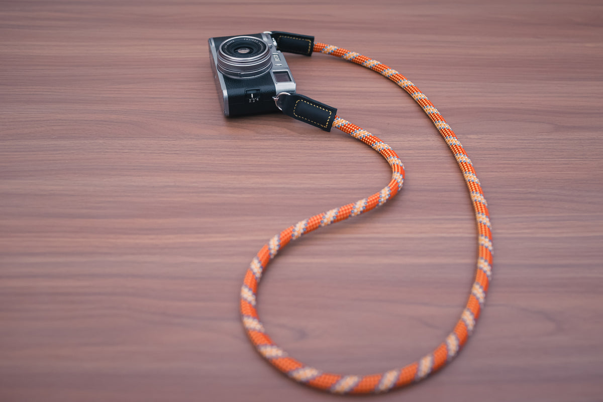 Close-up of orange climbing rope with a distinctive golden pattern