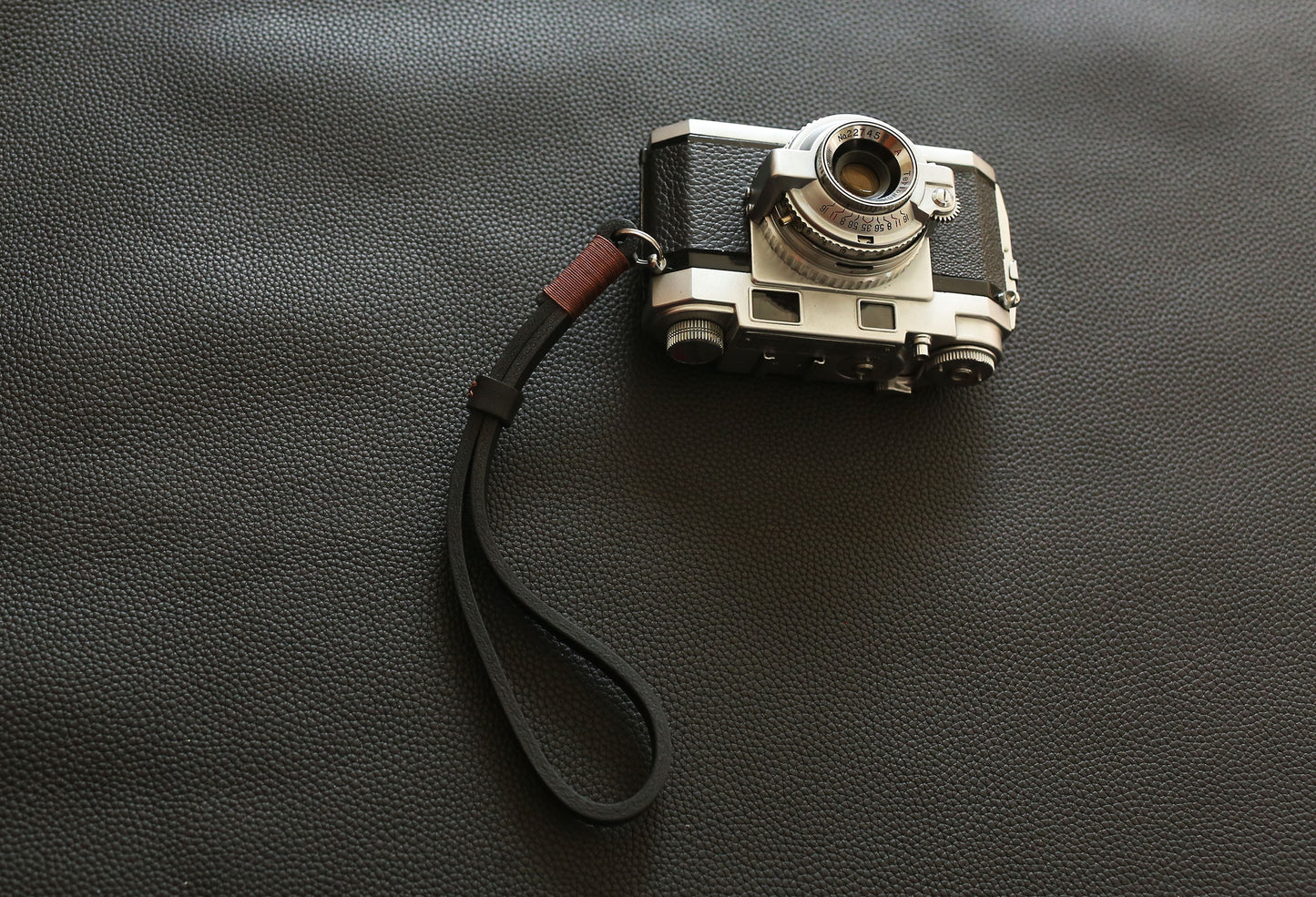 Heavy-duty leather wrist strap designed for professional mirrorless and film cameras