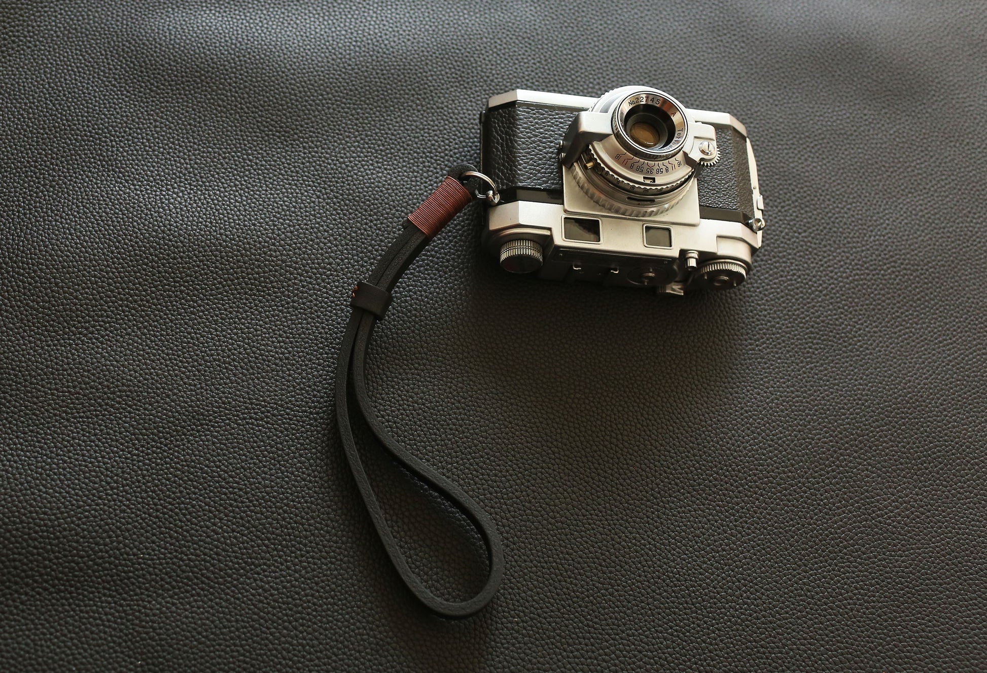 Heavy-duty leather wrist strap designed for professional mirrorless and film cameras