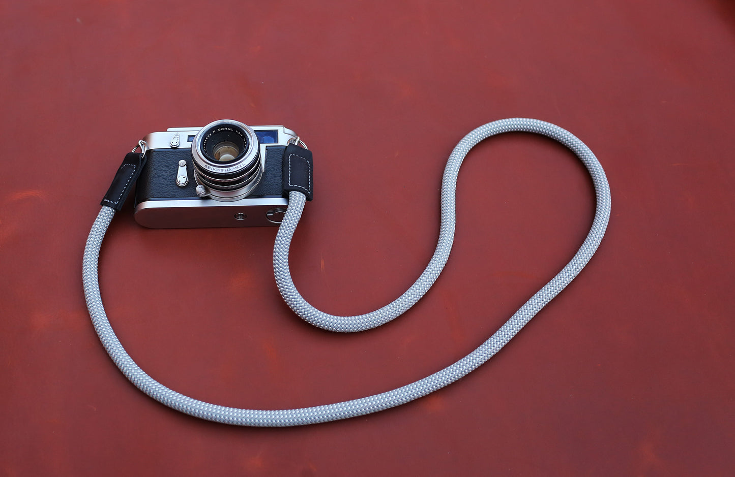 Spotted Ash grey rope camera strap mounted on a silver Leica M rangefinder.