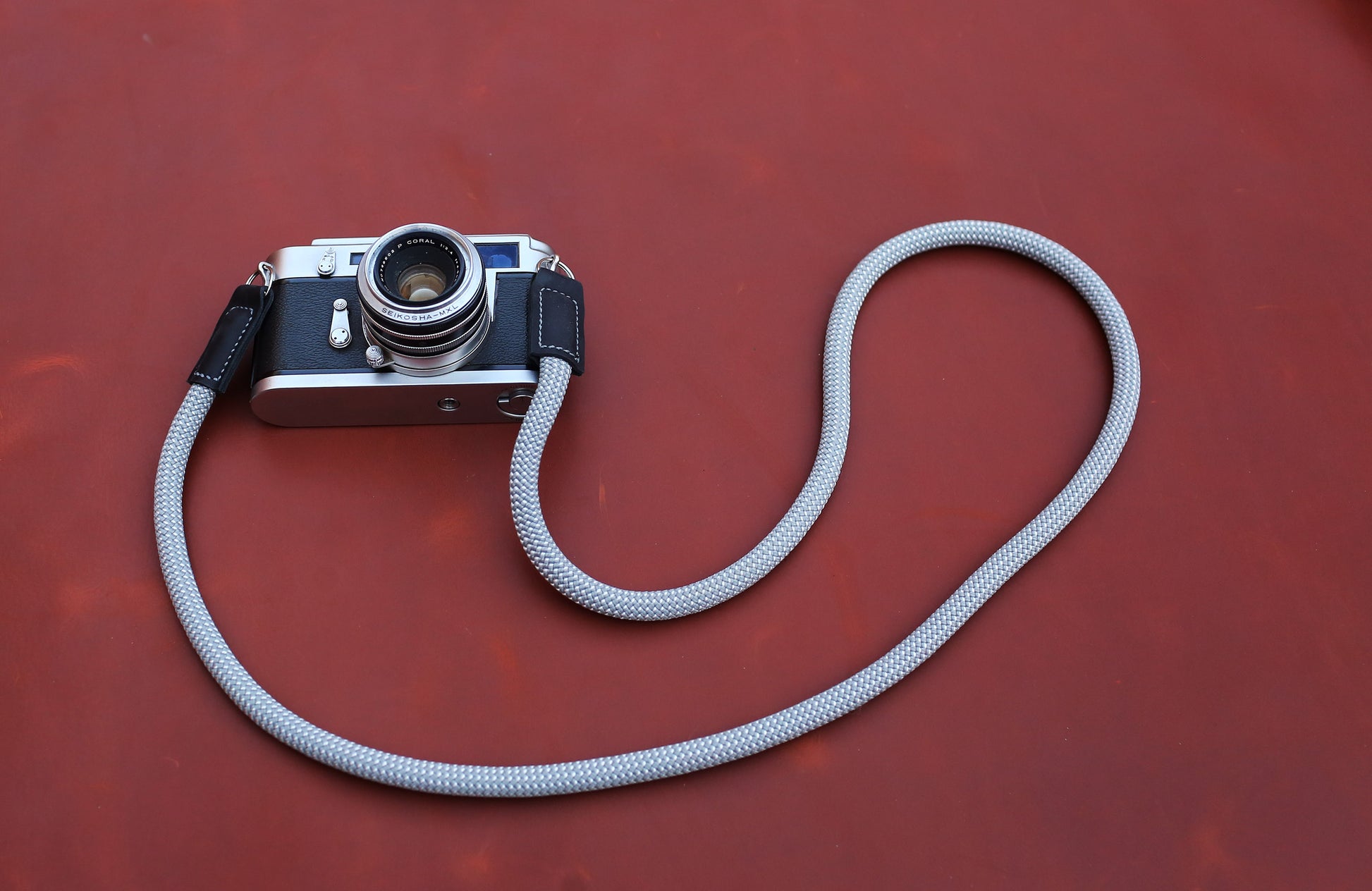 Spotted Ash grey rope camera strap mounted on a silver Leica M rangefinder.