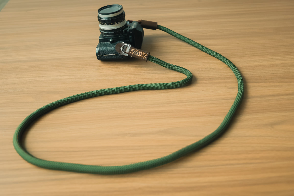Army green rope camera strap attached to a mirrorless camera