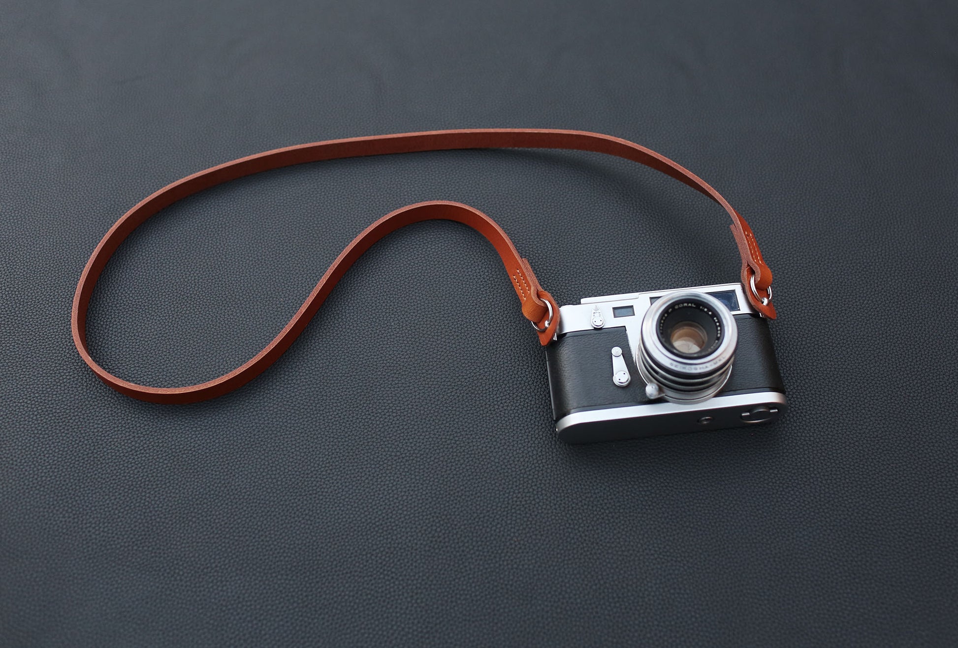 Tan leather camera strap on table