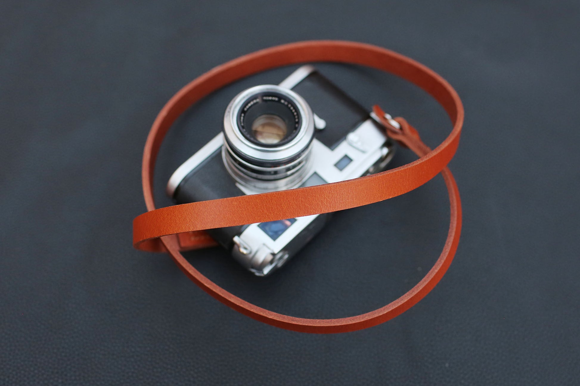 Tan strap attached to vintage camera