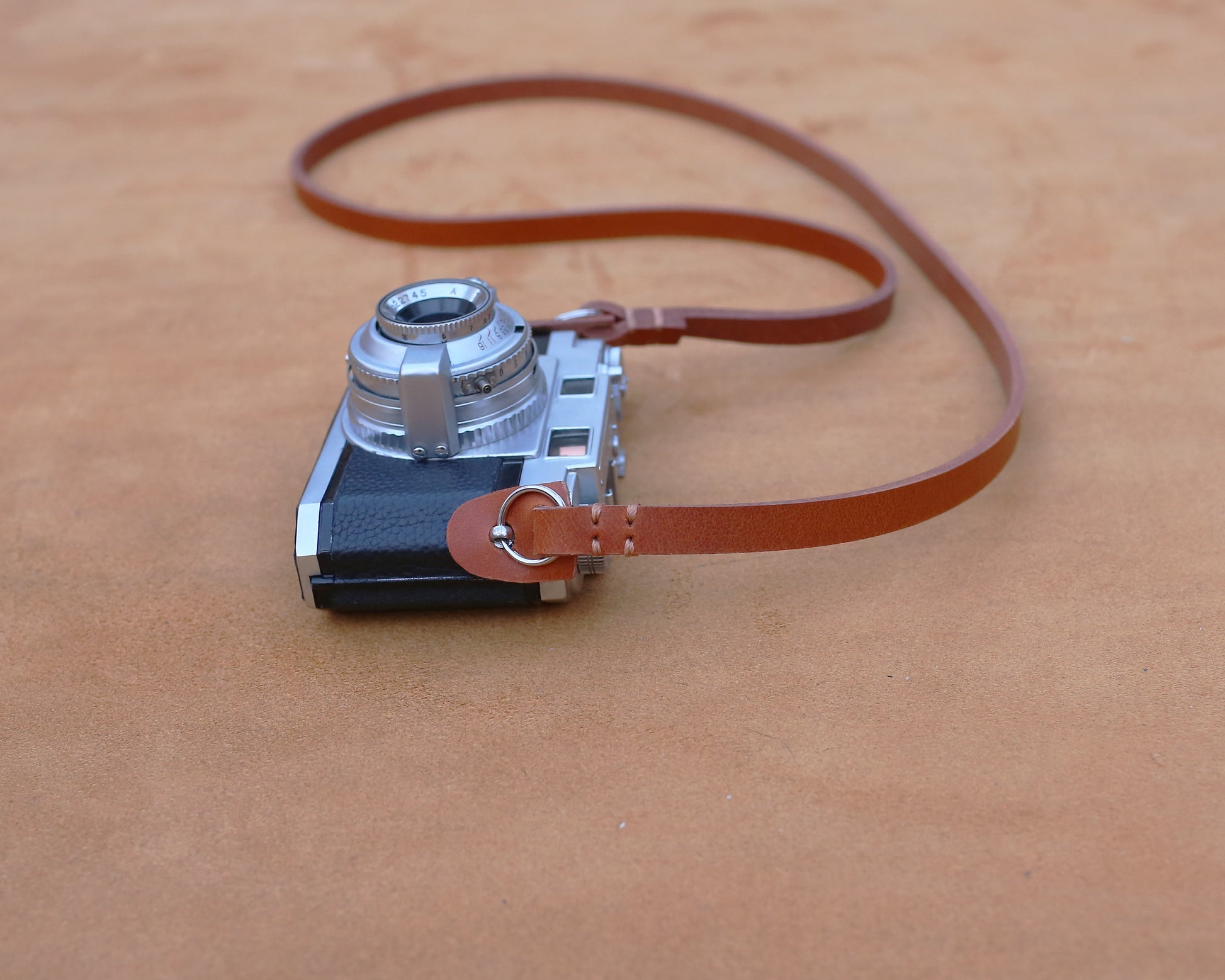 Vintage-inspired brown leather camera strap on a retro silver film camera