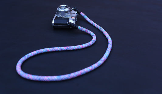 Flexible violet woven camera strap demonstrating gentle elasticity