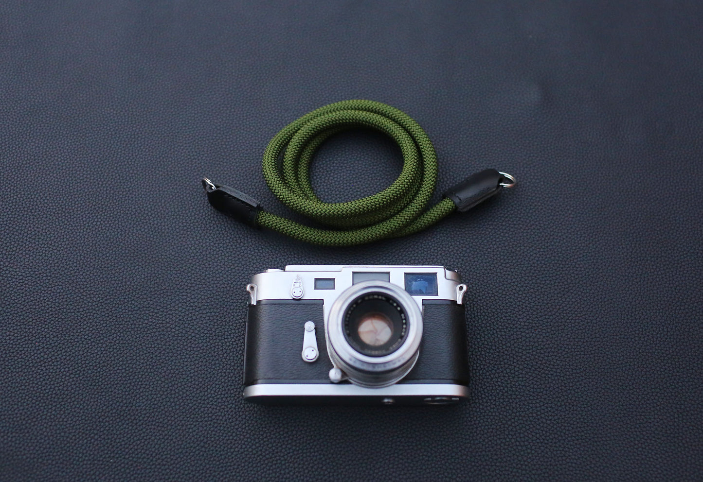 handcrafted army green rope camera strap photographed under soft studio light