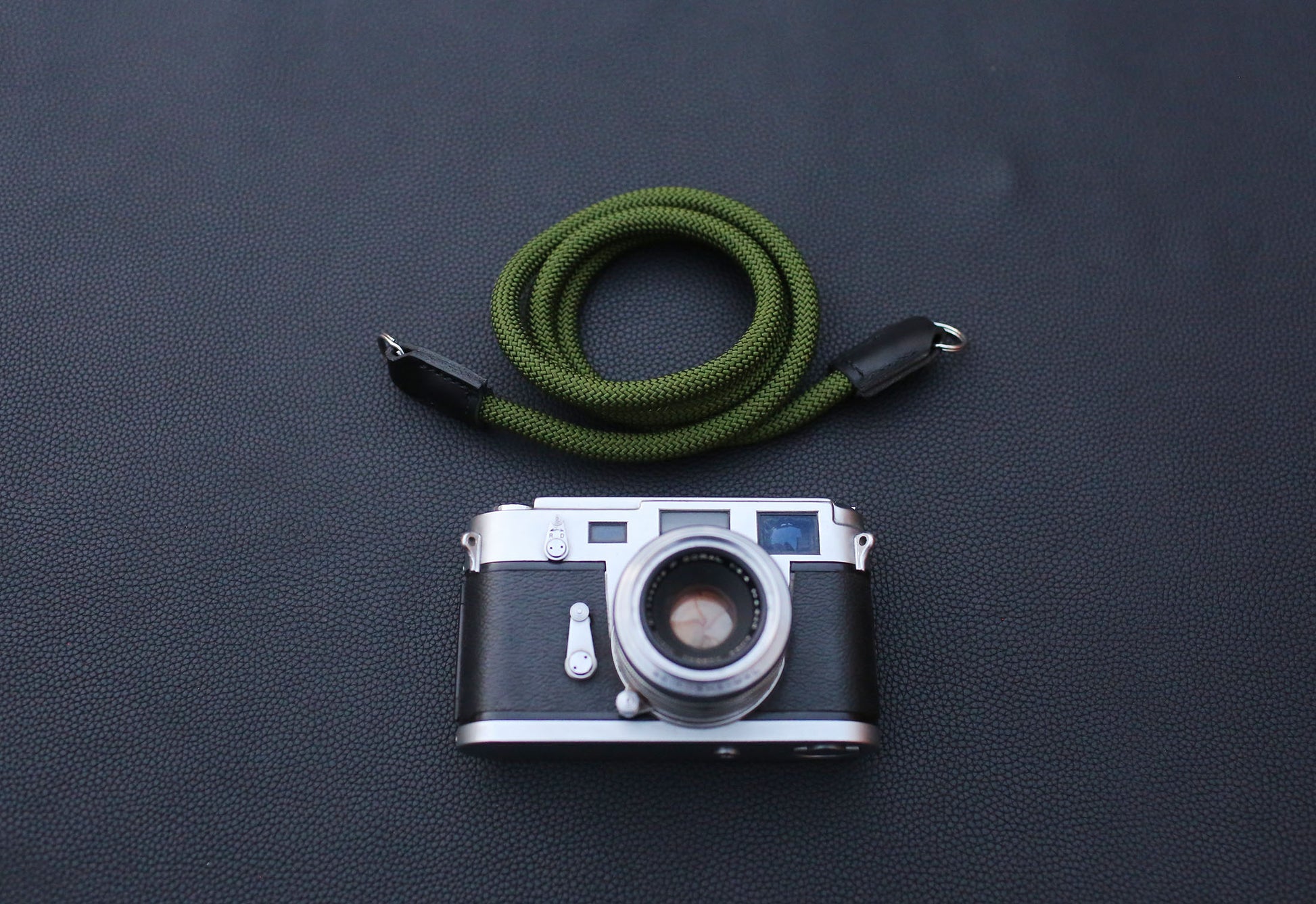 handcrafted army green rope camera strap photographed under soft studio light
