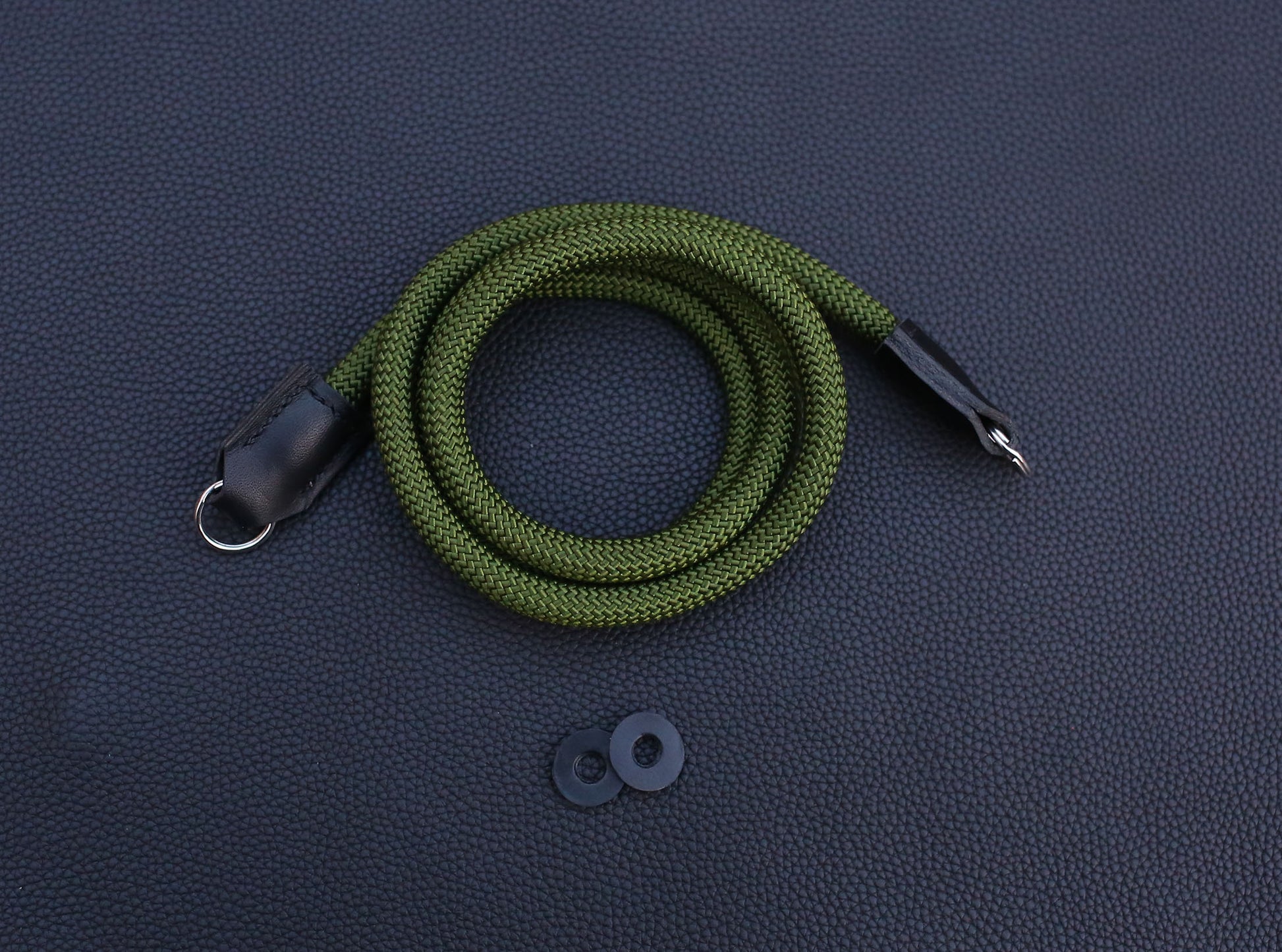 closeup view showing texture of army green climbing rope and hand stitching