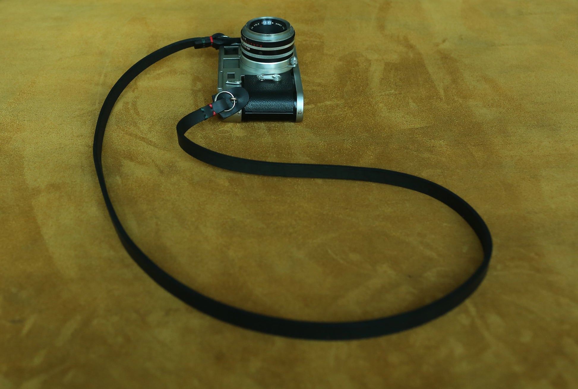 Windmup black artisan camera sling featuring hand-waxed red and green thread details