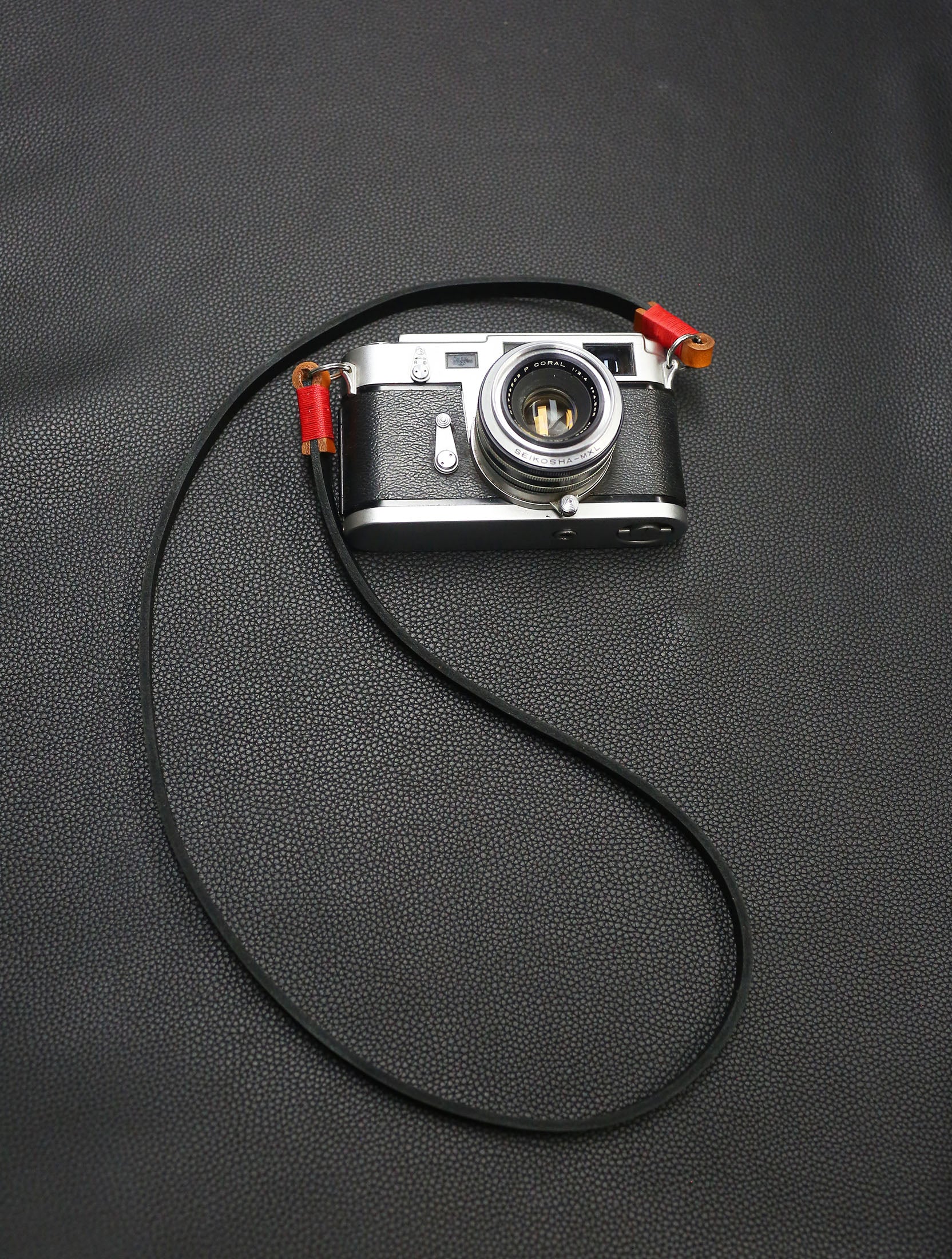 Handmade black leather camera strap with red waxed thread by Windmup.